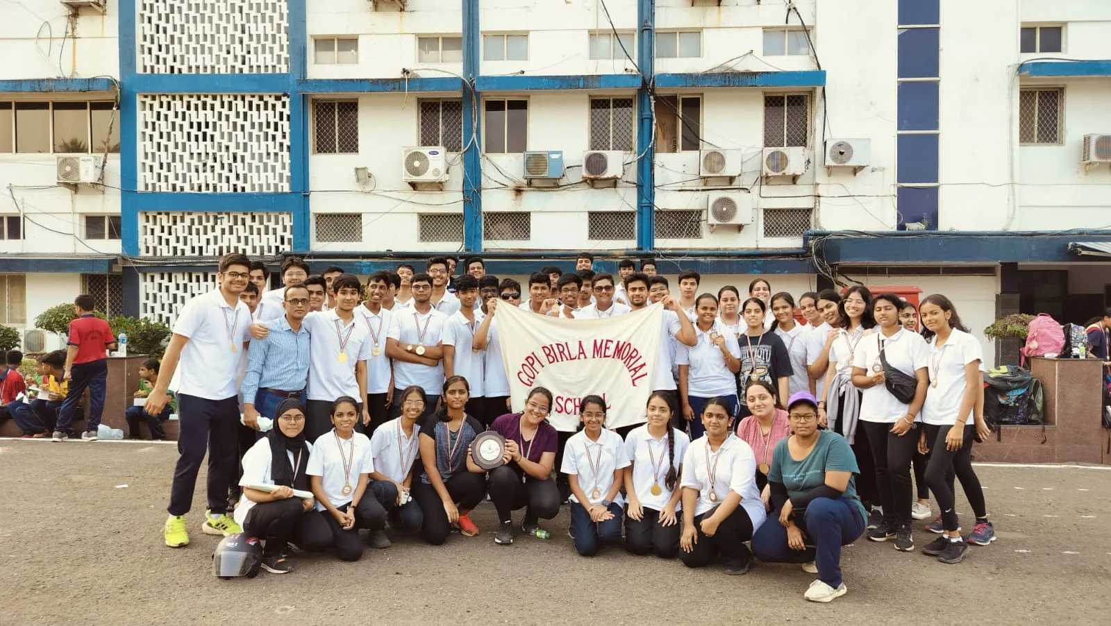 A diverse group of elementary students gathered around a globe.
