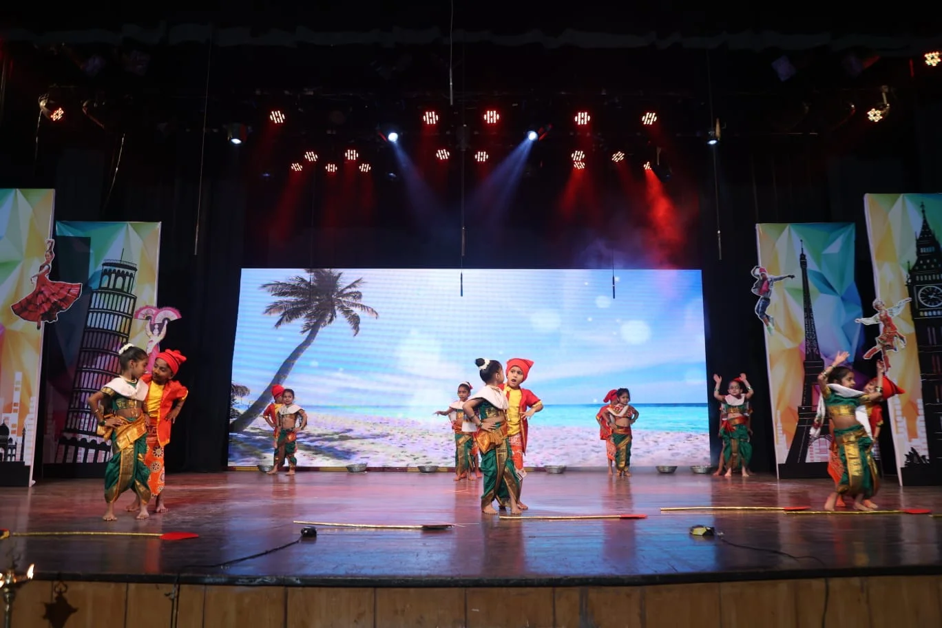 A female teacher and a student sitting at a desk in a modern classroom.